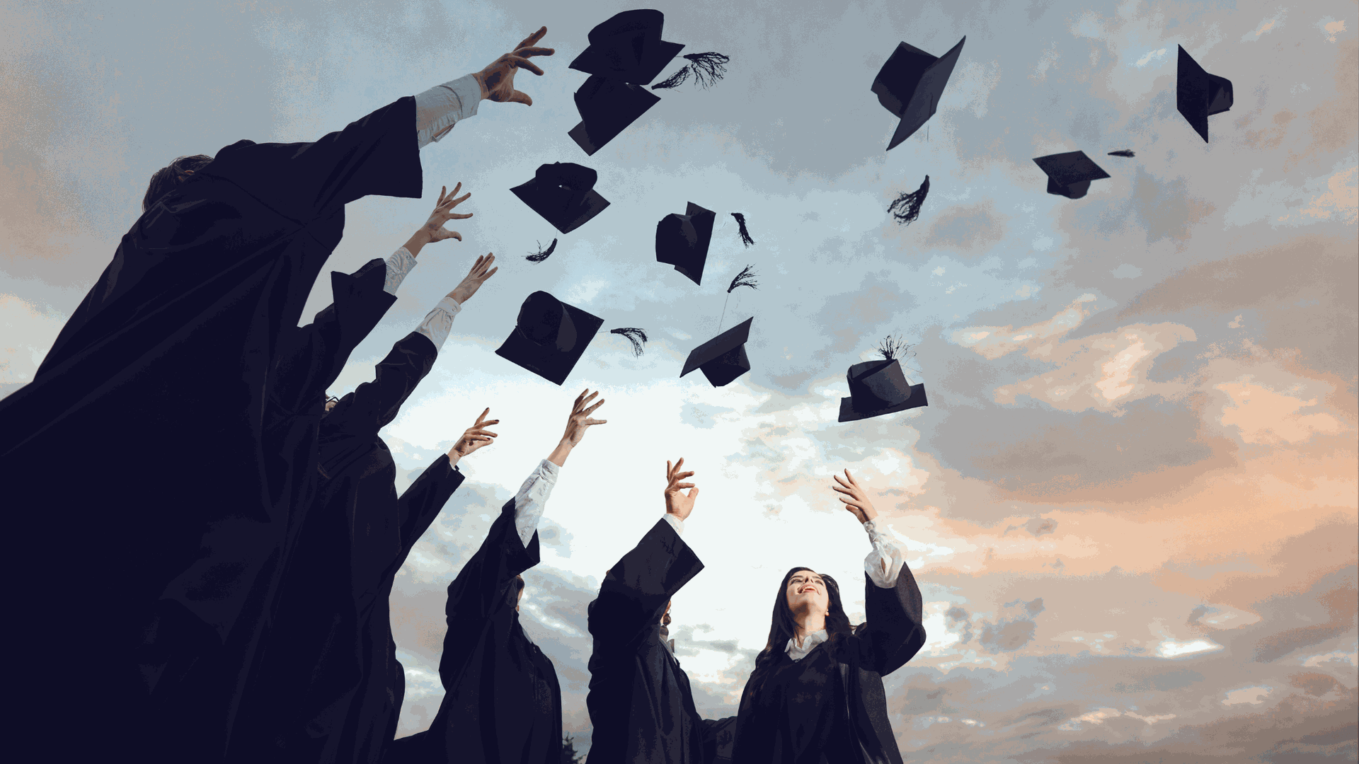 university graduates celebrating throwing hats