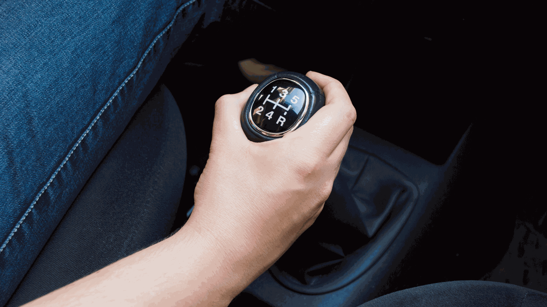 man shifting car gears